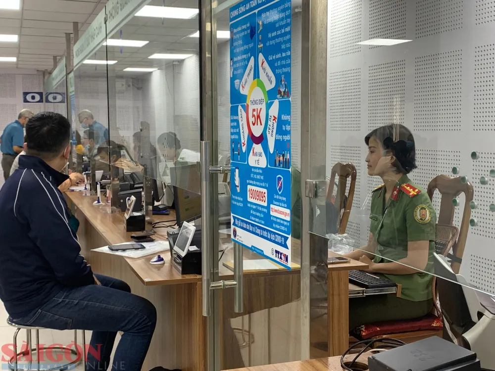 Cán bộ làm thủ tục cho người dân tại quầy. Ảnh: CHÍ THẠCH