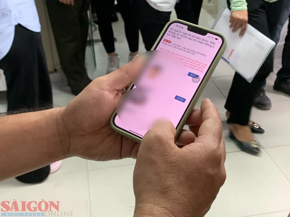 Cán bộ công an hướng dẫn cho người dân làm thủ tục qua dịch vụ công. Ảnh: CHÍ THẠCH