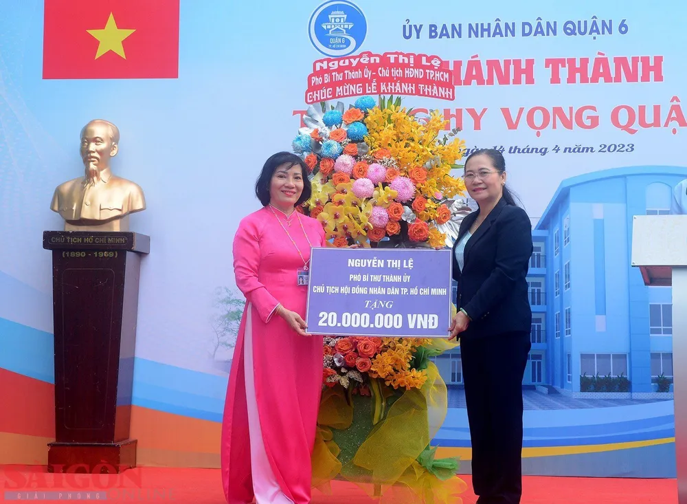 Chủ tịch HĐND TPHCM Nguyễn Thị Lệ tặng hoa, quà chúc mừng. Ảnh: CHÍ THẠCH