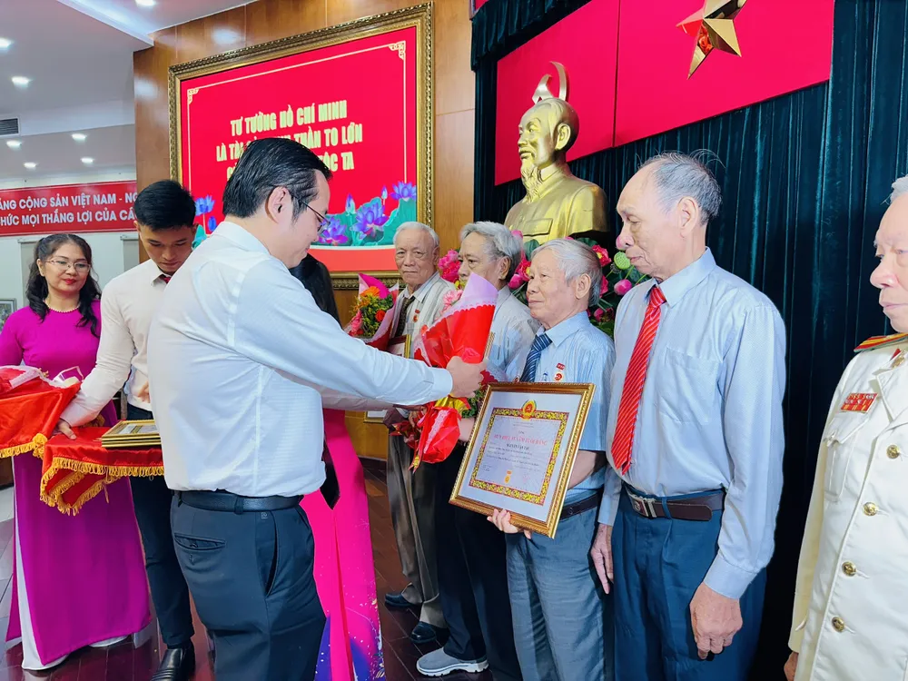 Bí thư Quận ủy quận 10 Lê Văn Minh trao Huy hiệu Đảng cho đảng viên cao tuổi. Ảnh: CHÍ THẠCH