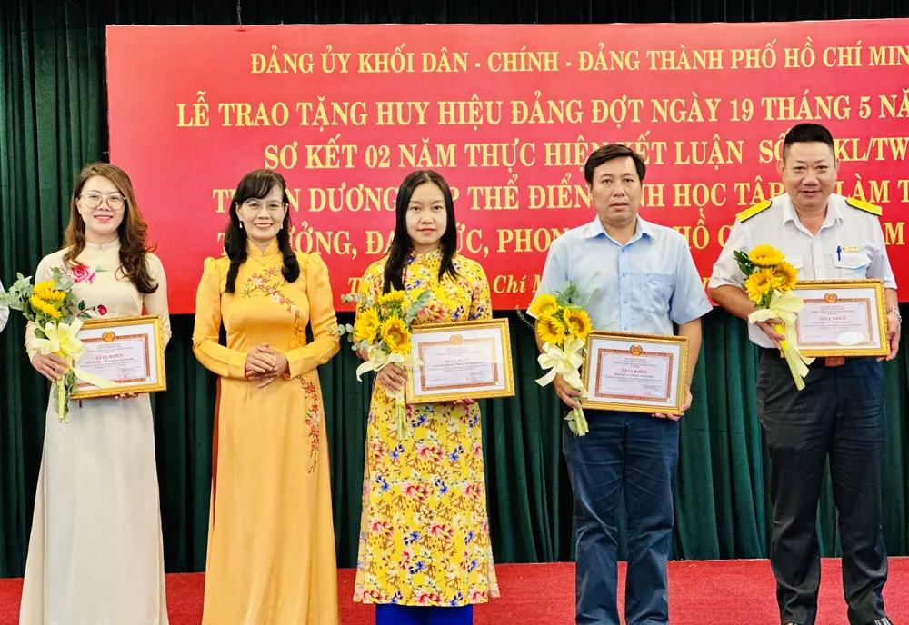 Phó Bí thư Đảng ủy Khối Dân – Chính – Đảng TPHCM Hàng Thị Thu Nga (thứ 2 từ trái qua) trao bằng khen cá nhân, tập thể tham gia cuộc thi viết về công tác phòng, chống dịch Covid-19 trên địa bàn TPHCM. Ảnh: CHÍ THẠCH