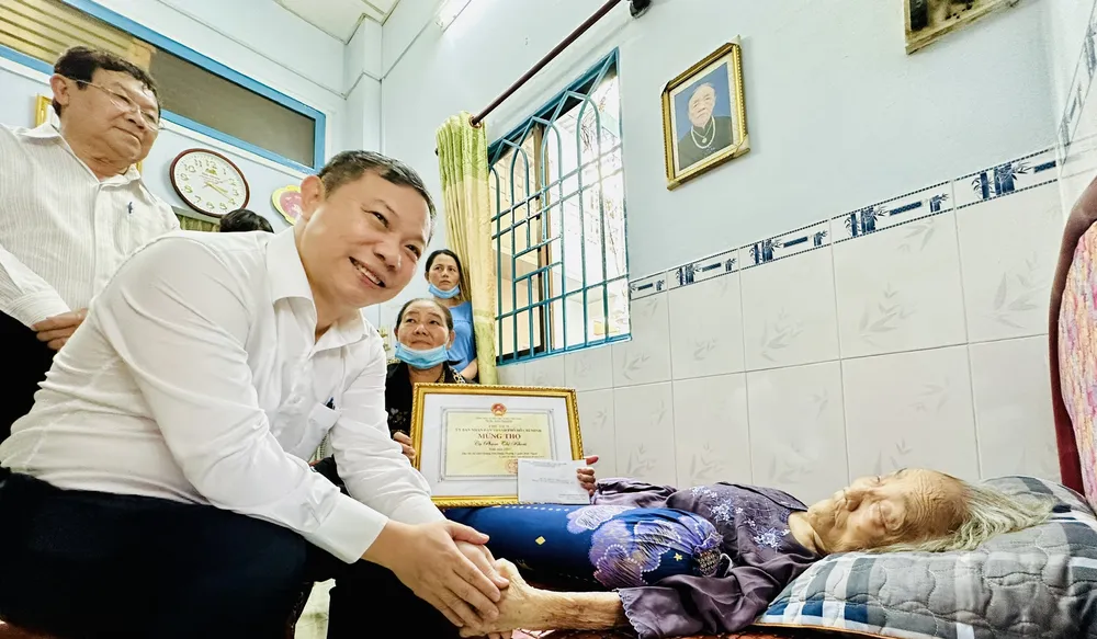 Phó Chủ tịch UBND TPHCM Dương Anh Đức thăm hỏi sức khỏe, chế độ ăn uống, sinh hoạt của cụ Phạm Thị Khoái. Ảnh: CHÍ THẠCH