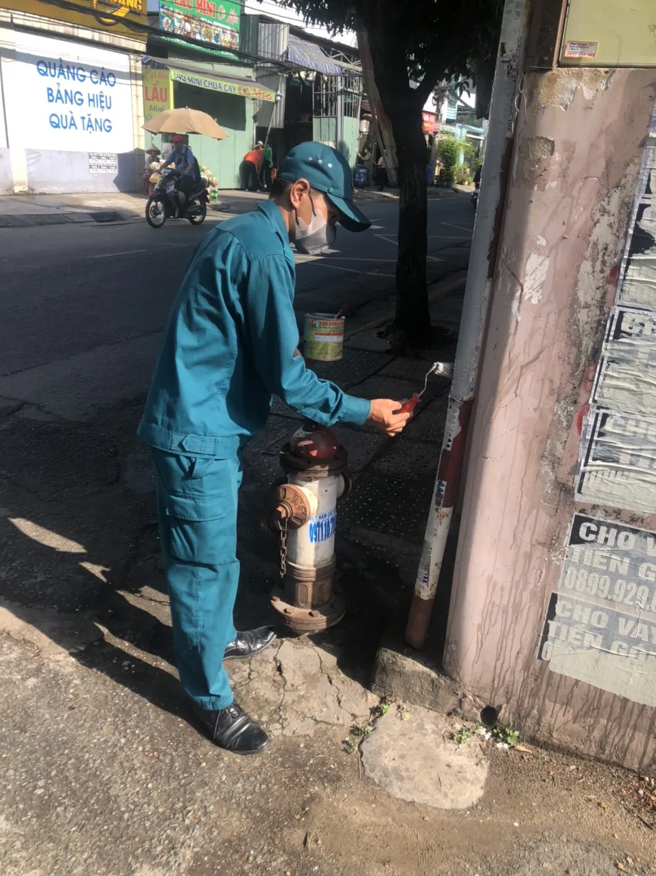 Lực lượng chức năng sơn lại trụ sau khi bóc gỡ quảng cáo bẩn