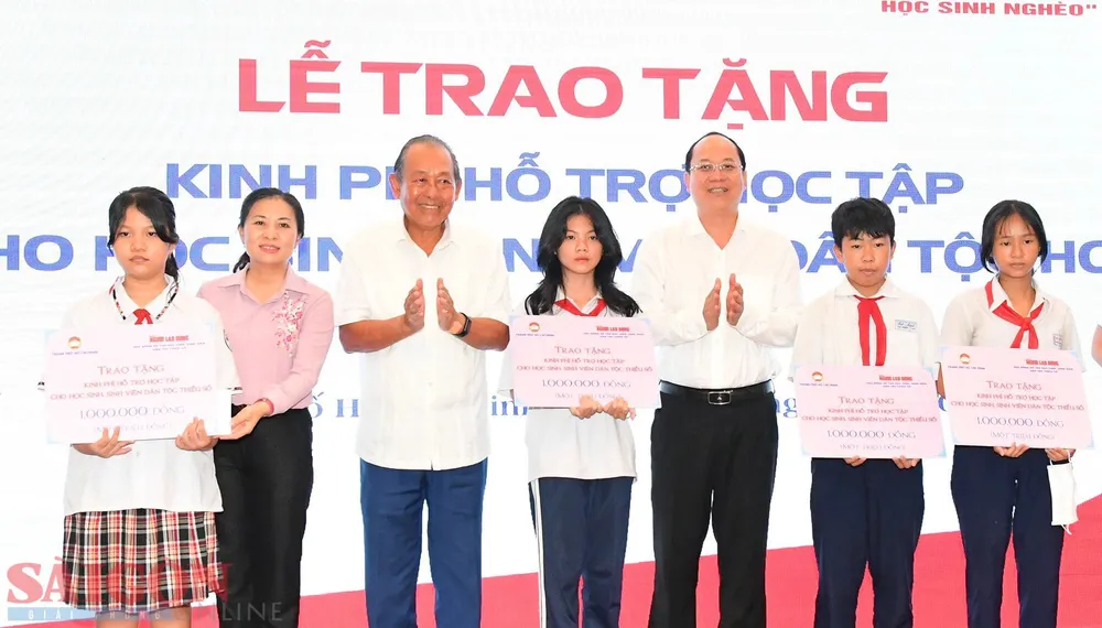 Đồng chí Trương Hòa Bình và đồng chí Nguyễn Hồ Hải trao kinh phí hỗ trợ cho các em học sinh. Ảnh VIỆT DŨNG