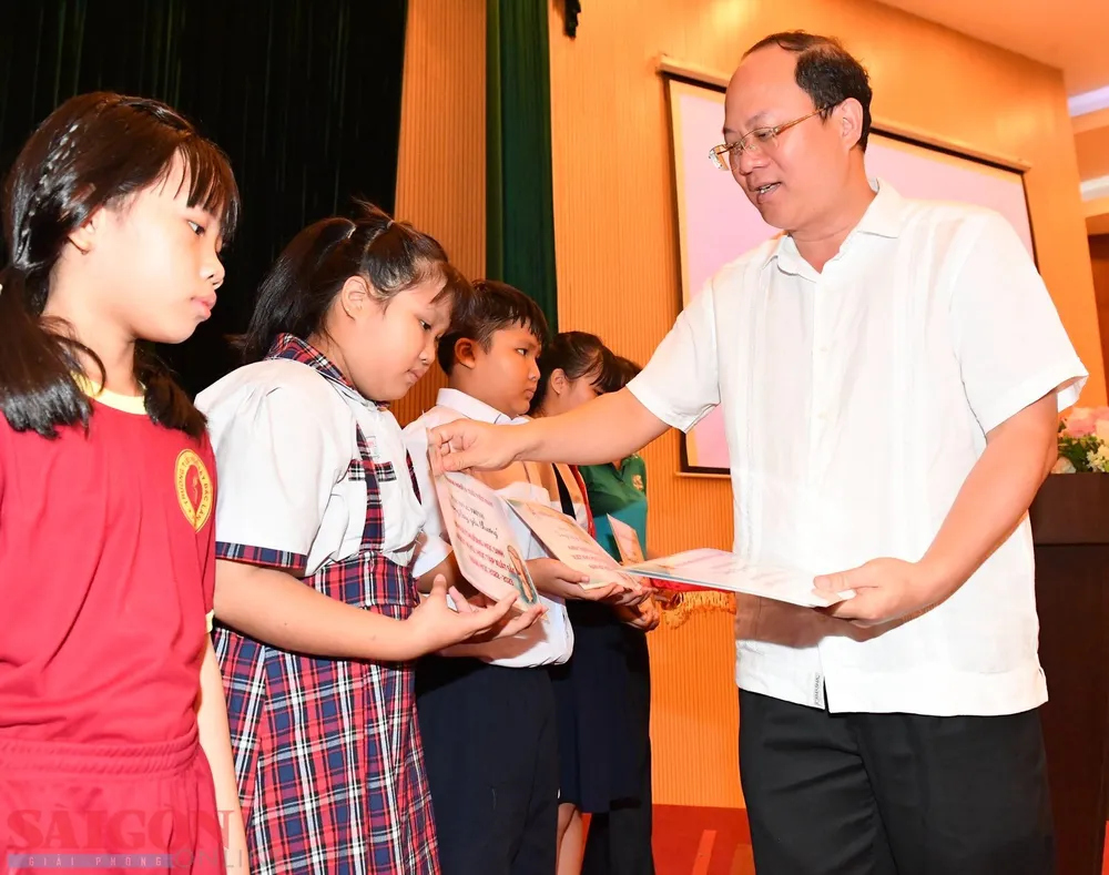 Phó Bí thư Thành ủy TPHCM Nguyễn Hồ Hải trao quà cho các em có hoàn cảnh khó khăn. Ảnh VIỆT DŨNG