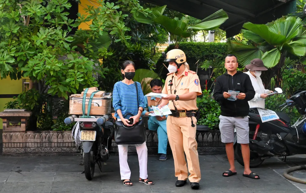 CSGT TPHCM phát tờ rơi tuyên truyền cho phụ huynh ngồi chờ các em học sinh thi