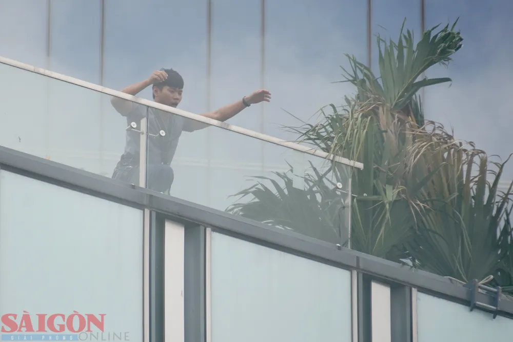 Người mắc kẹt trên tầng cao tòa nhà hoảng loạn kêu cứu. Ảnh: HOÀNG HÙNG