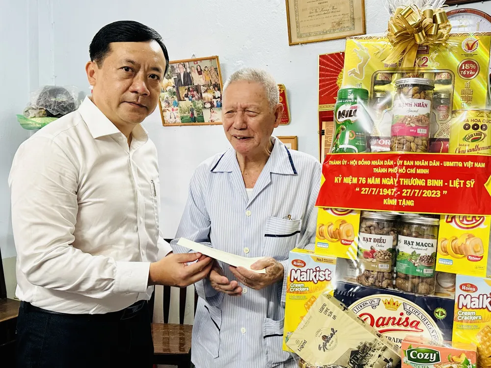Phó Trưởng đoàn chuyên trách Đoàn đại biểu Quốc Hội TPHCM Hà Phước Thắng ân cần thăm hỏi tặng quà ông Vũ Văn Vận, là thân nhân liệt sĩ. Ảnh: CHÍ THẠCH