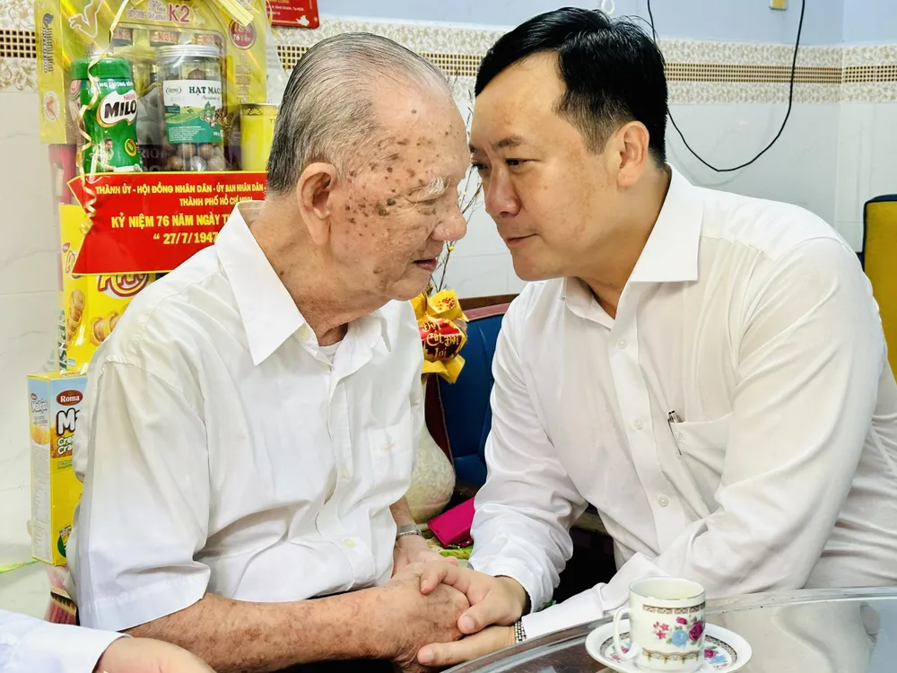 Phó Trưởng đoàn chuyên trách Đoàn đại biểu Quốc Hội TPHCM Hà Phước Thắng ân cần thăm hỏi ông Lương Hiền Lành, là thân nhân liệt sĩ. Ảnh: CHÍ THẠCH