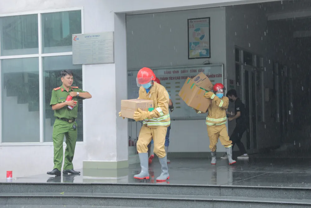Người dân cùng lực lượng chức năng di chuyển đồ đạc ra bên ngoài