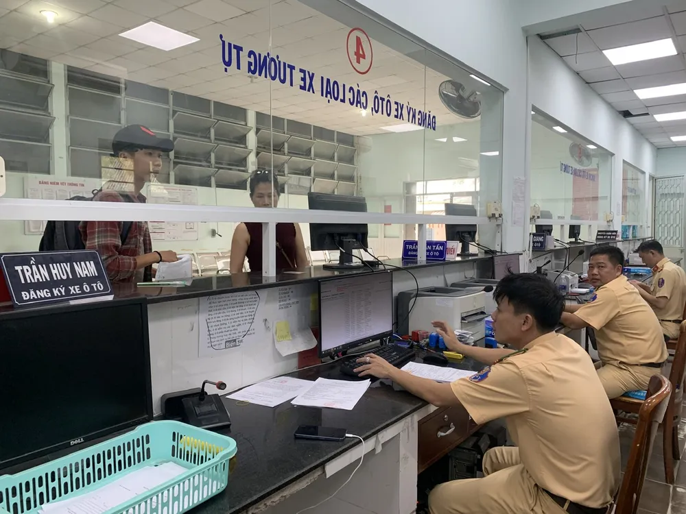 CSGT TPHCM hướng dẫn người dân làm thủ tục cấp đổi biển số. Ảnh: CHÍ THẠCH