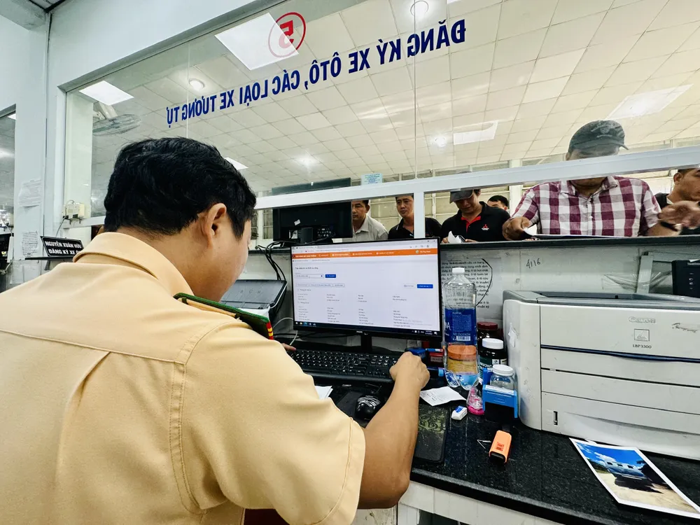 Làm thủ tục cho người dân. Ảnh: CHÍ THẠCH