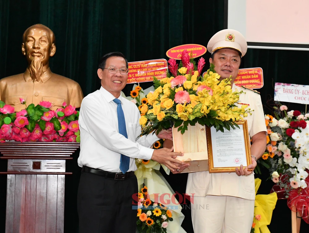 Chủ tịch UBND TPHCM Phan Văn Mãi chúc mừng tân Phó Giám đốc Công an TPHCM Nguyễn Đình Dương. Ảnh: VIỆT DŨNG 