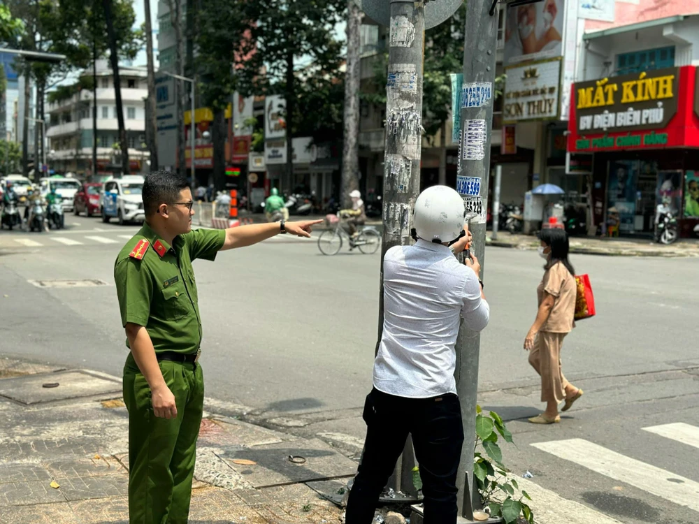 Công an đưa chủ nhà trọ bóc xóa chính những quảng cáo mà người này đã dán