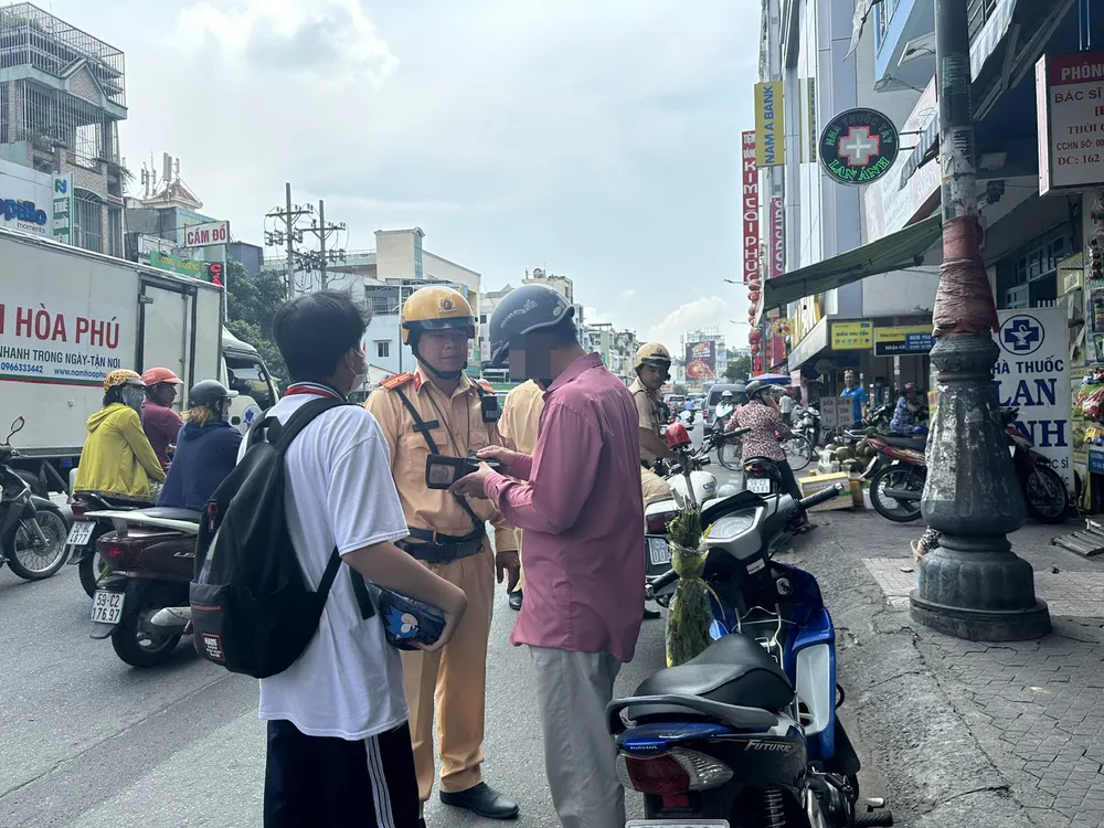 Một phụ huynh chở con không đội nón bảo hiểm bị xử phạt