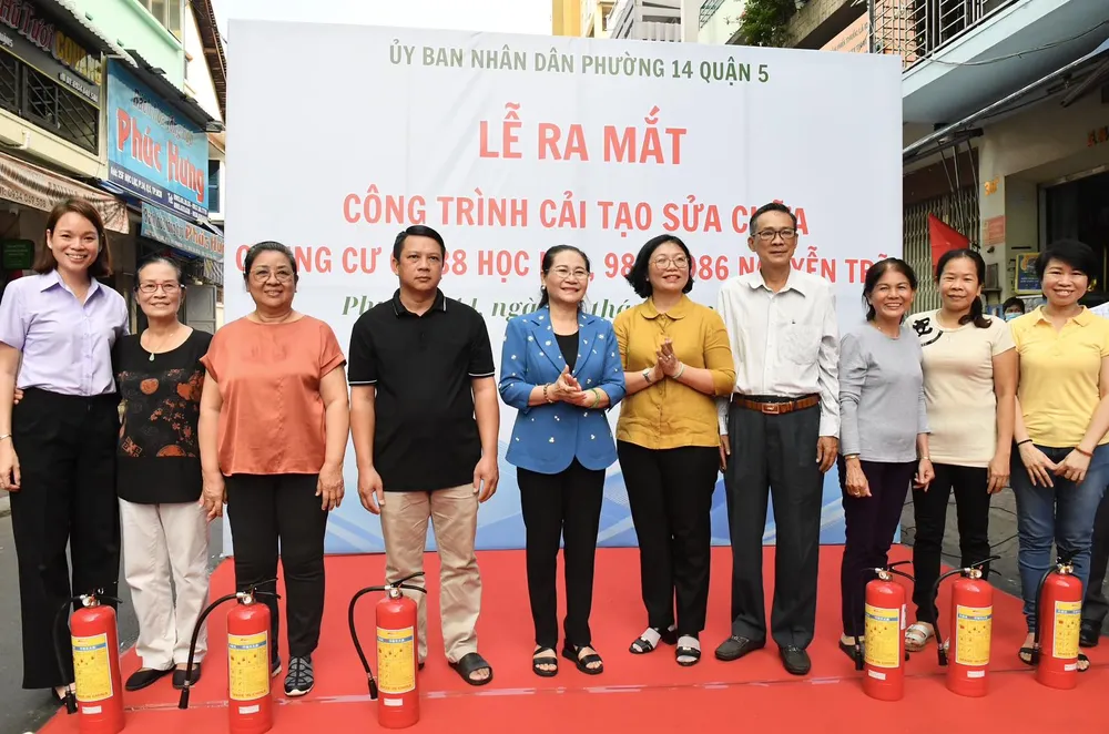 Chủ tịch HĐND TPHCM Nguyễn Thị Lệ, Bí thư quận ủy quận 5 Huỳnh Ngọc Nữ Phương Hồng trao tặng bình chữa cháy đến các hộ dân. Ảnh: VIỆT DŨNG