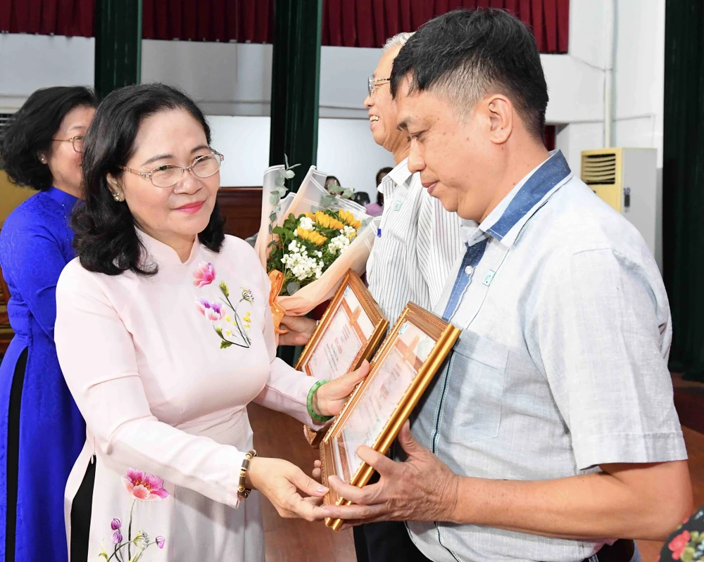 Đồng chí Nguyễn Thị Lệ trao Bằng khen của Ban Thường vụ Thành ủy TPHCM cho đảng viên hoàn thành xuất sắc nhiệm vụ 5 năm liền. Ảnh: VIỆT DŨNG img-2686-7740.jpg