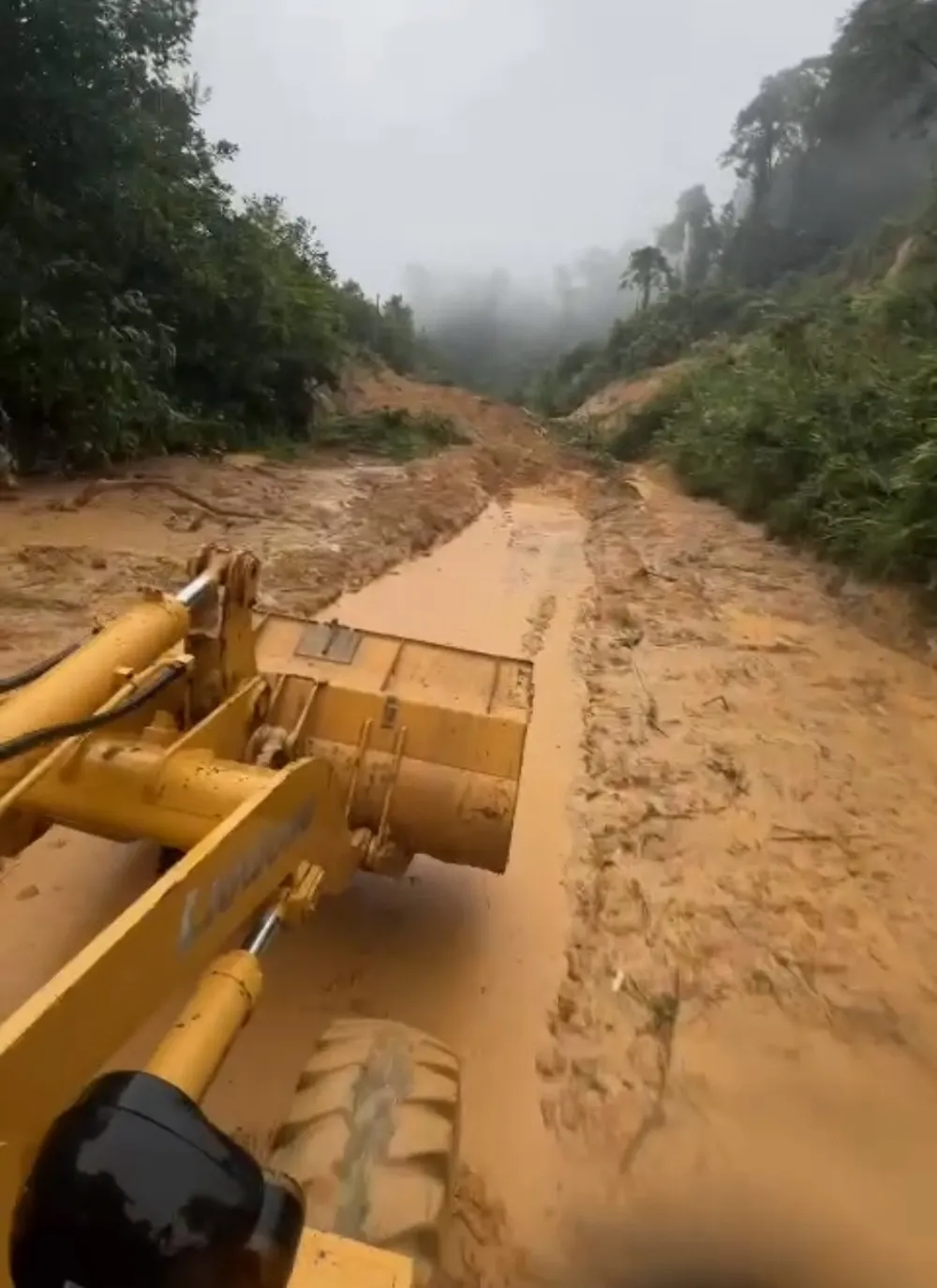 Các đơn vị quản lý đường bộ đang dùng máy hót sụt, san gạt mặt đường trên các tuyến ở khu vực miền Trung bị sụt trượt. Ảnh Cục Đường bộ Việt Nam cung cấp. 1000013099.jpg
