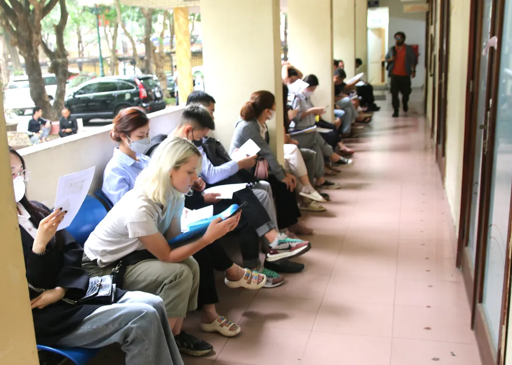 Trước cửa nơi giao dịch một cửa, nhiều người ngồi chờ cán bộ gọi số thứ tự Trước cửa nơi giao dịch một cửa, nhiều người ngồi chờ cán bộ gọi số thứ tự