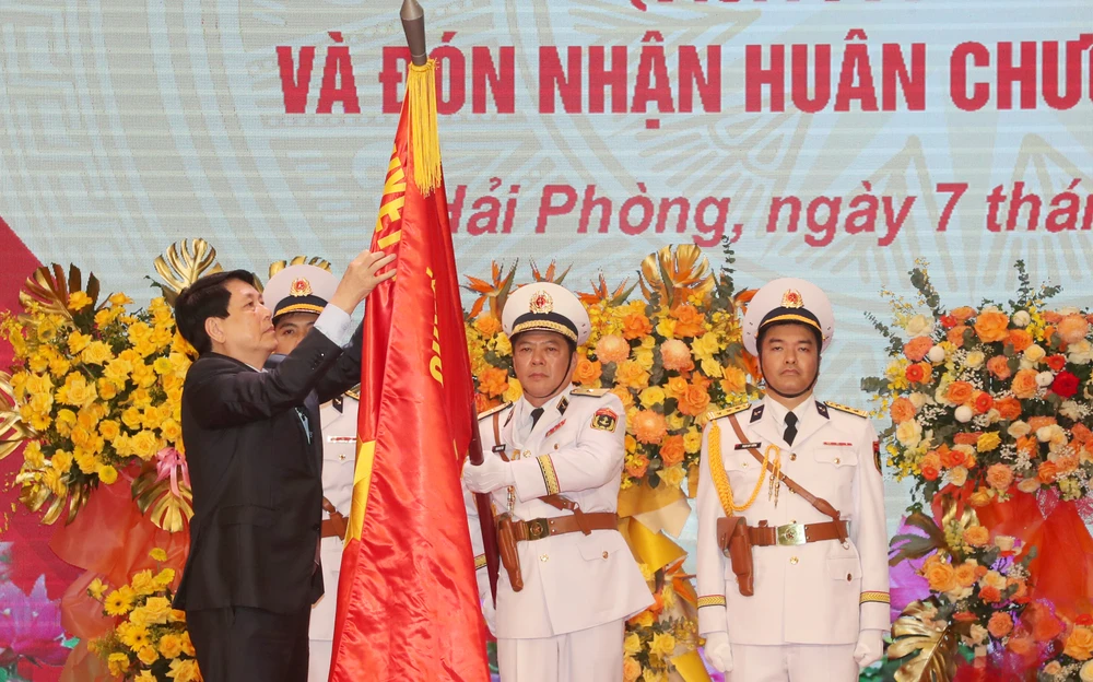 Chủ tịch nước Lương Cường gắn Huân chương Hồ Chí Minh lên cờ quyết chiến quyết thắng của Quân chủng Hải quân. Ảnh: Quân chủng Hải quân cung cấp 9.jpg