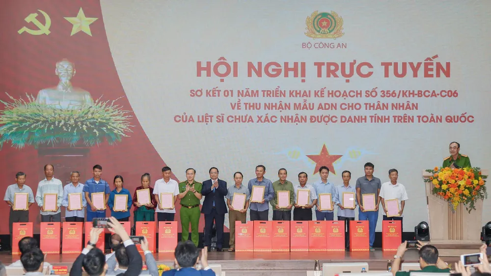 Thủ tướng Phạm Minh Chính trao thông báo kết quả giám định ADN hài cốt liệt sĩ đến đại diện gia đình liệt sĩ. Ảnh: PHÙNG ANH Thủ tướng trao.jpg
