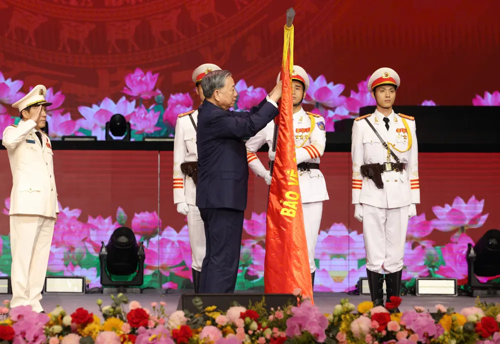 Tổng Bí thư Tô Lâm gắn Huân chương Sao vàng lên Cờ truyền thống lực lượng công an nhân dân. Ảnh: QUANG PHÚC z6915397887499_eaf921427902e498cbbc71f1b64cab74.jpg