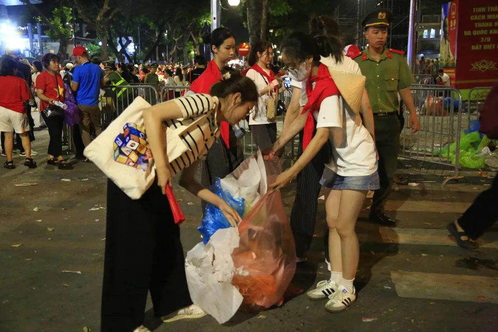 Người trẻ đi nhặt rác, gom vào túi tập kết về các xe rác. Ảnh: HÀ NGUYỄN 2.jpg