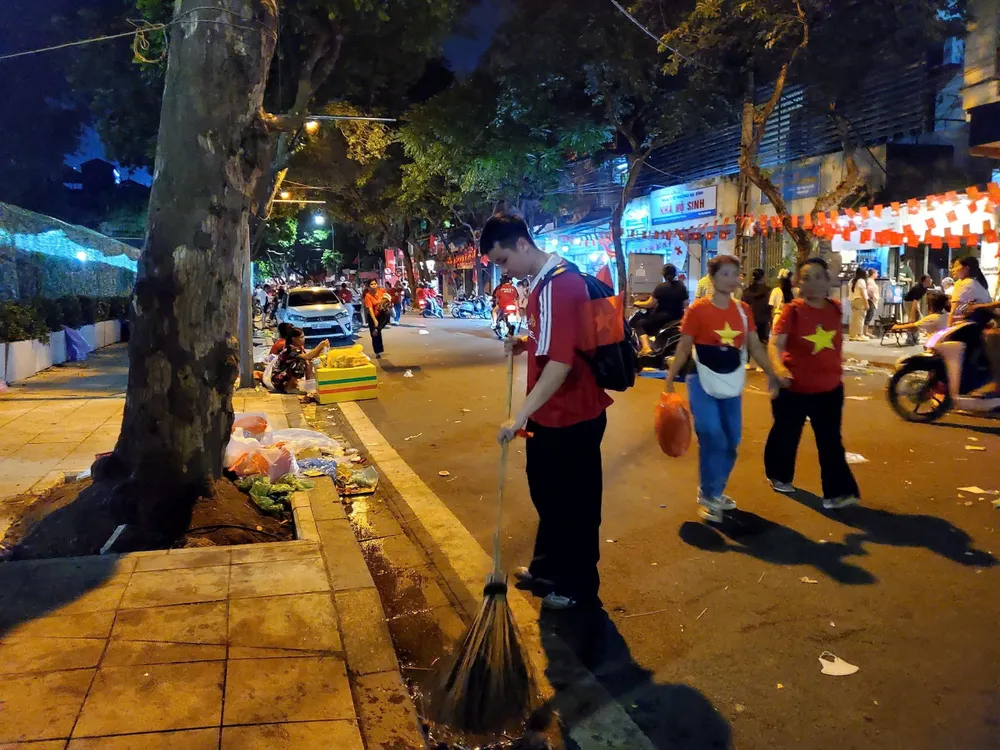 Một bạn nam tham gia quét dọn đường phố sau buổi tối hợp luyện 24-8, tại phố Lê Trực. Ảnh: HÀ NGUYỄN 5.jpg