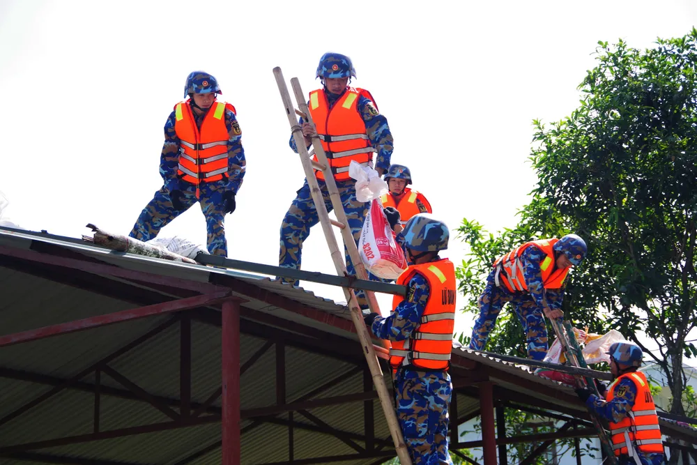 Cán bộ, chiến sĩ Lữ đoàn 170 giúp dân đặt bao cát lên mái nhà chống bão Cán bộ, chiến sĩ Lữ đoàn 170 giúp dân đặt bao cát lên mái nhà chống bão.jpg