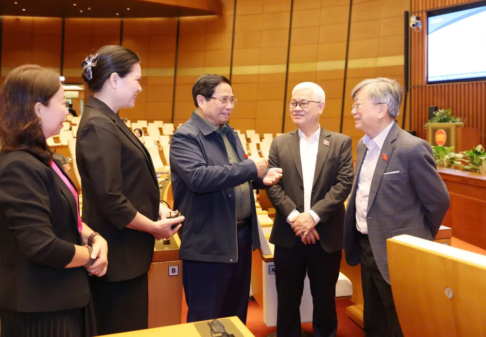 Thủ tướng Phạm Minh Chính trao đổi với các đại biểu Quốc hội tại phiên thảo luận về kế hoạch phát triển kinh tế - xã hội, sáng 29-10. Ảnh: QUANG PHÚC trao đổi.jpg