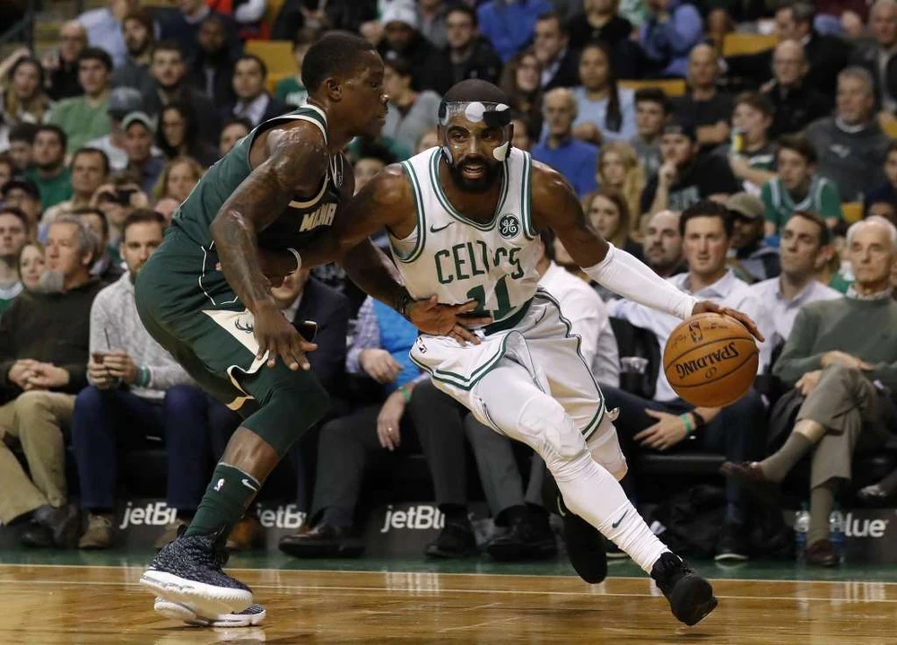 Kyrie Irving (phải) đi bóng trước sự truy cản của Eric Bledsoe (Bucks)