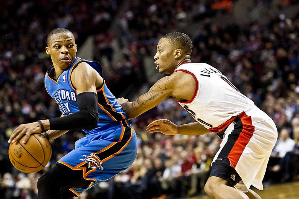 Russell Westbrook (trái) trong một pha tranh bóng với Damien Lillard