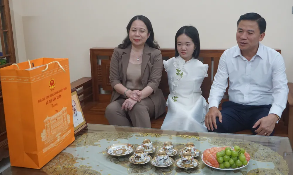 Phó Chủ tịch nước Võ Thị Ánh Xuân và Bí thư Tỉnh ủy Thanh Hóa Đỗ Trọng Hưng thăm, tặng quà cho cô giáo Lê Thị Thắm. Ảnh: NGUYỄN NAM