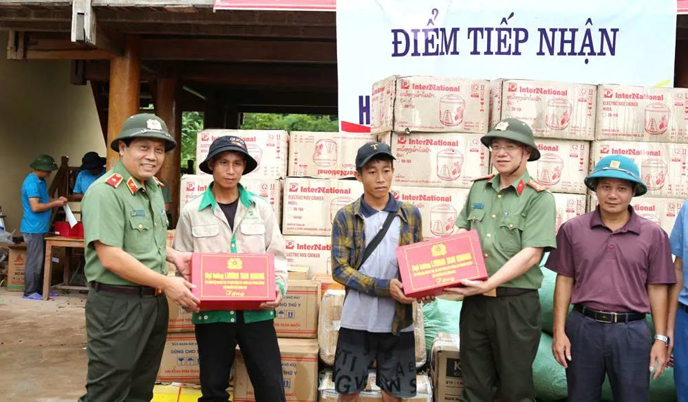 Thiếu tướng Nguyễn Hồng Nguyên, Phó Chánh Văn phòng Bộ Công an và Đại tá Đinh Việt Dũng, Giám đốc Công an tỉnh Nghệ An trao quà của Bộ trưởng Bộ Công an Lương Tam Quang đến bà con vùng lũ trao quà.jpg
