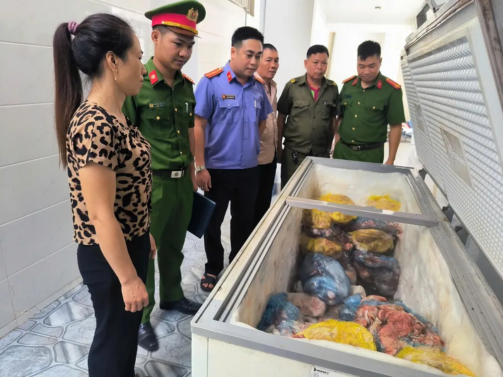 Cơ quan chức năng kiểm tra số thịt heo cất giữ trong nhà của đối tượng Nguyễn Thị Mai. Ảnh: CÔNG AN NGHỆ AN kiểm tra heo bẹnh.jpg
