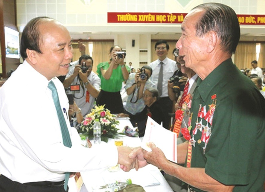 阮春福總理問候對革命有功者。（圖片來源：互聯網）