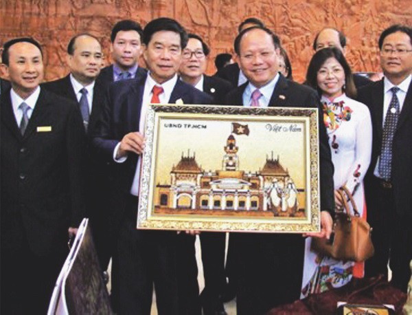 畢成剛同志向首都萬象領導贈送米畫。（圖片來源：互聯網）