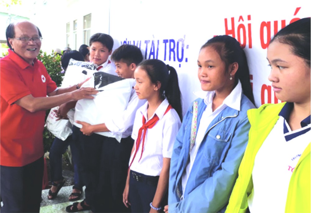 溫陵會館常值副理事長洪世真贈送禮物給 貧困學生。