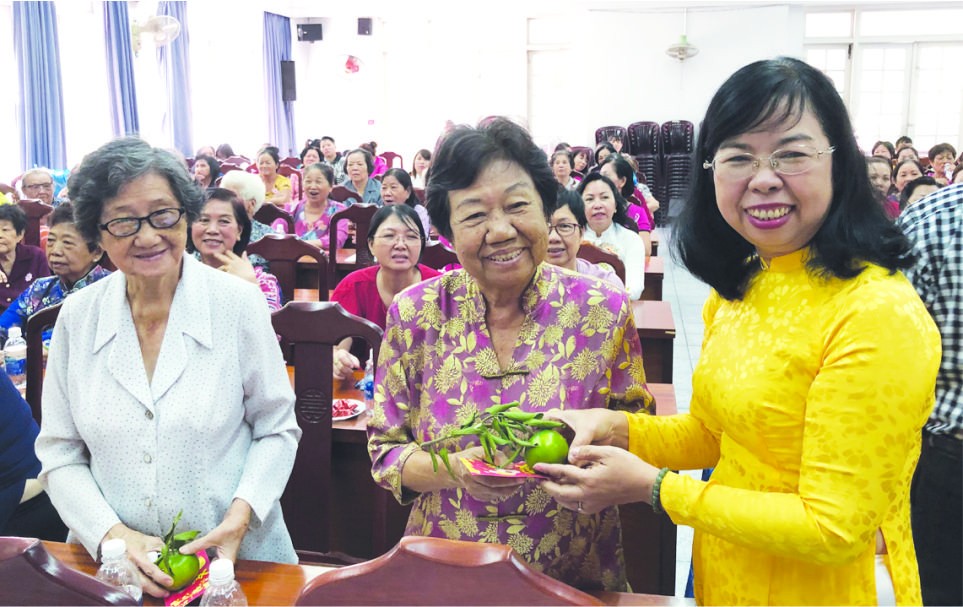 市婦聯會副主席杜氏政（右一）向民族婦女 派發紅包。