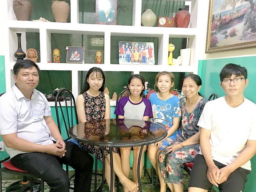 SOS村負責人陳煌俊（左）和黃氏玉耶母子們在其溫馨住宅中合影。