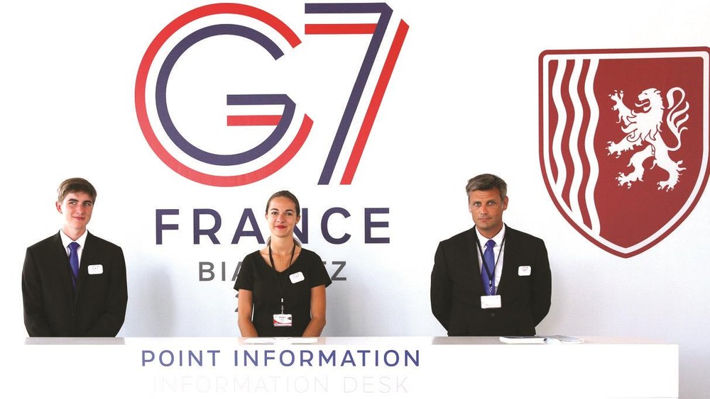 在法國比亞里茨，工作人員在新聞中心迎接媒體記者。