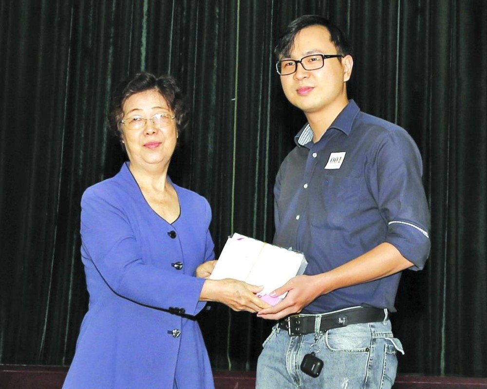 市越南祖國陣線委員會副主席、市各少數民族文學藝術協會主席劉金華頒發獎學金給碩士畢業生楊元昌。