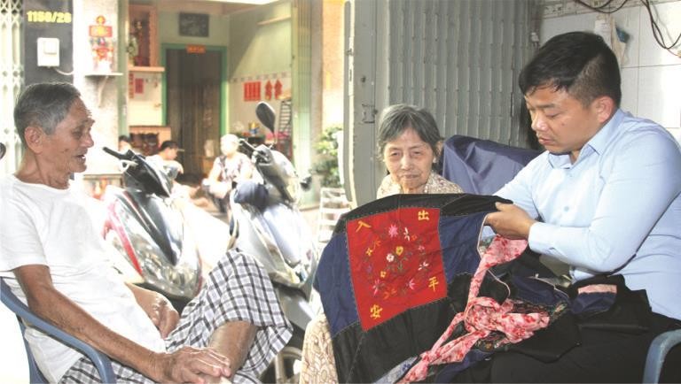 黃達銘老夫婦向麒麟（右一）贈送距今70多年其母親用於背著弟妹來越的“咩帶”。