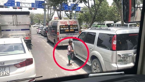 小孩子在本市-隆城-油曳高速公路與梅志壽街交叉路段行乞。