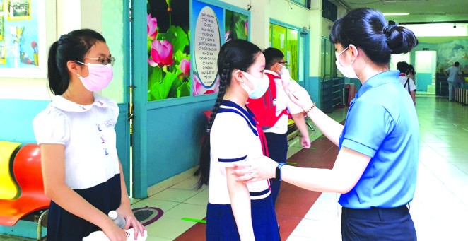 明道小學給五年級學生量體溫。