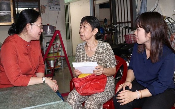 第八郡黨員向古氏深（中）問候和贈送輔助金。