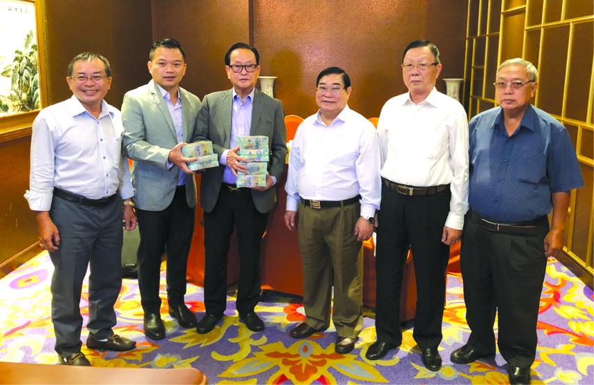 　　萬盛發集團代表張豐裕(左三)向 二府會館和建築商移交第二期捐款。