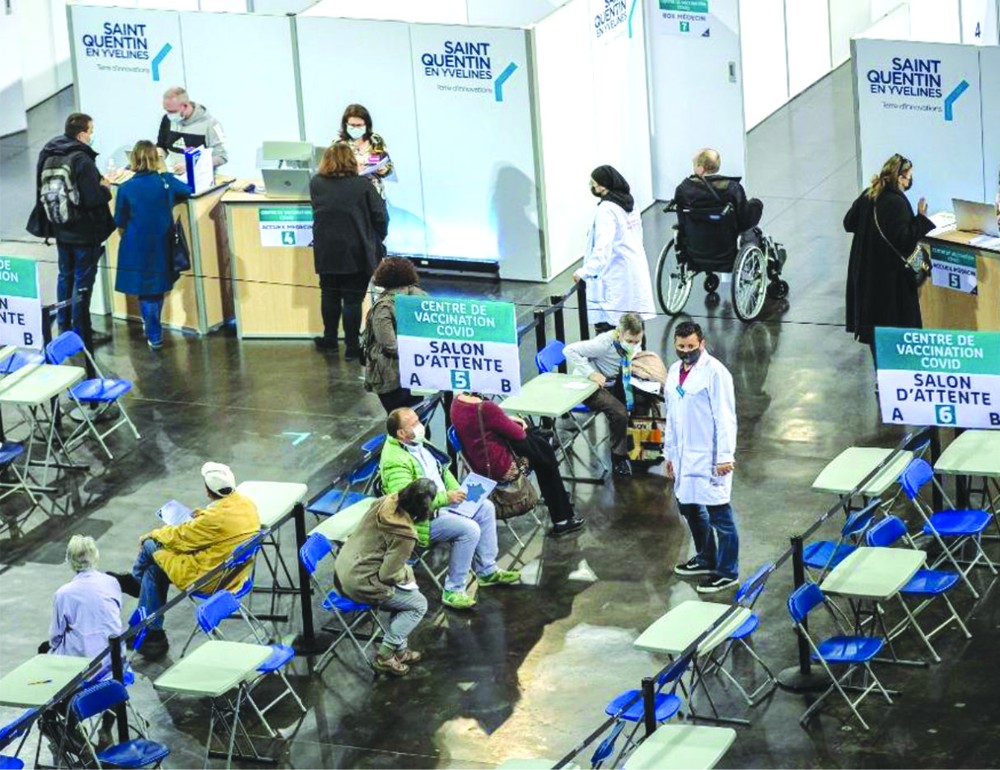 人們在法國一家體育館設立的新冠疫苗接種中心等待接種疫苗。