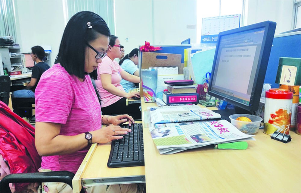 華文《西貢解放日報》編譯員正在工作。