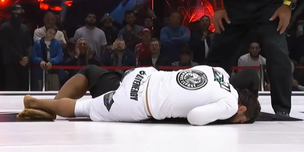 Tsarukyan (võ phục trắng) trong tư thế áp mặt xuống sàn để khóa siết Henderson